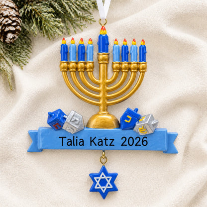 Personalized Hanukkah Menorah christmas ornament laid on a soft white knit blanket
