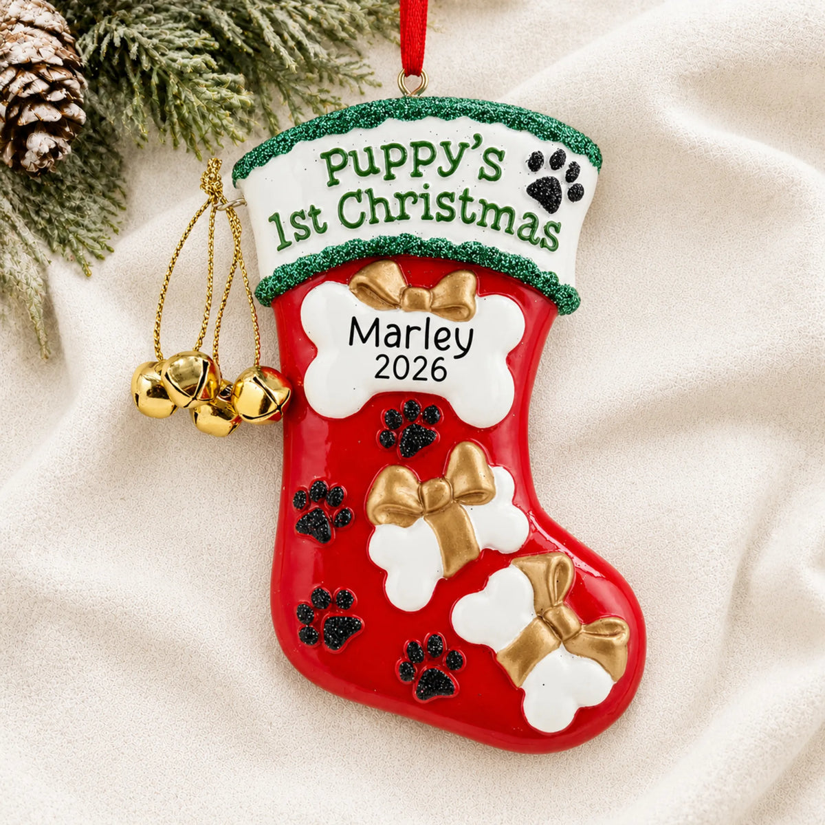 Personalized Puppy's First Christmas Stocking ornament laid on a soft white knit blanket