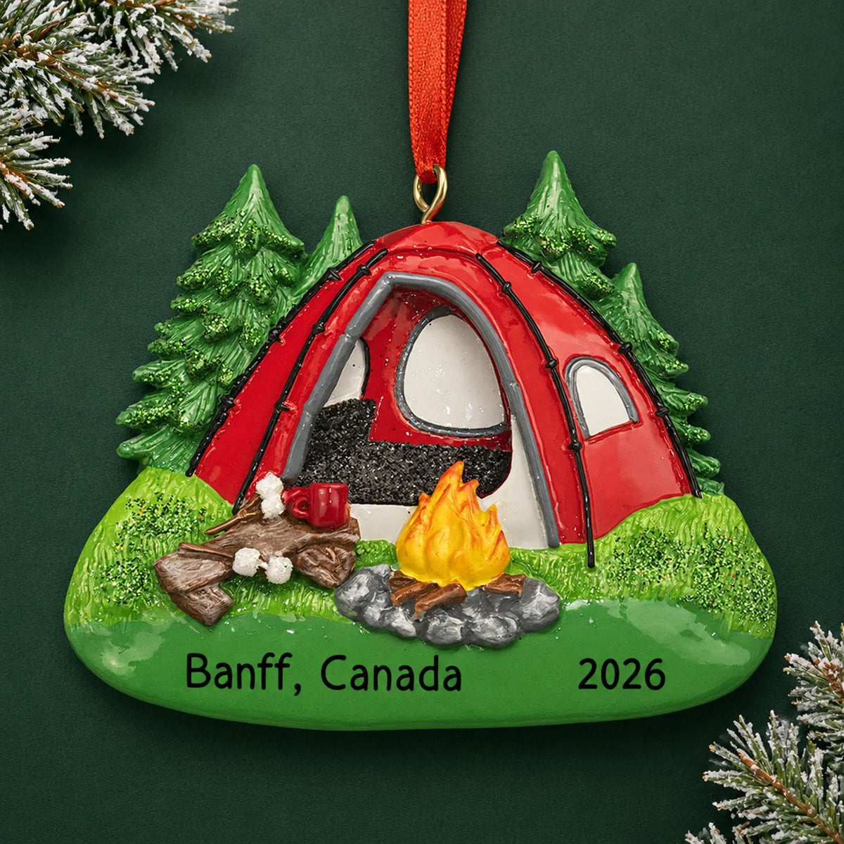 Personalized red camping tent christmas ornament on a dark green pine background