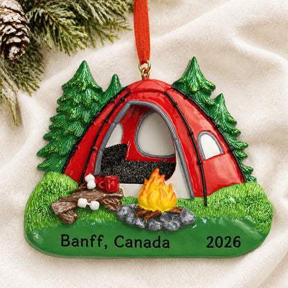 Personalized red camping tent christmas ornament laid on a soft white knit blanket